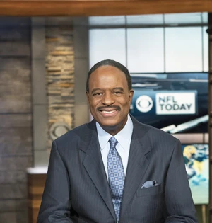 Man in suit in front of NFL Today sign.